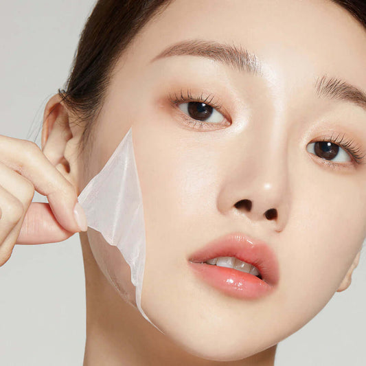 Woman gently peeling off a clear sheet mask, showcasing radiant skin and hydration.