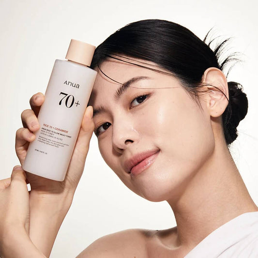 Model holding Anua Rice 70 Glow Milky Toner, showcasing radiant skin, a brightening toner for oily and combination skin.