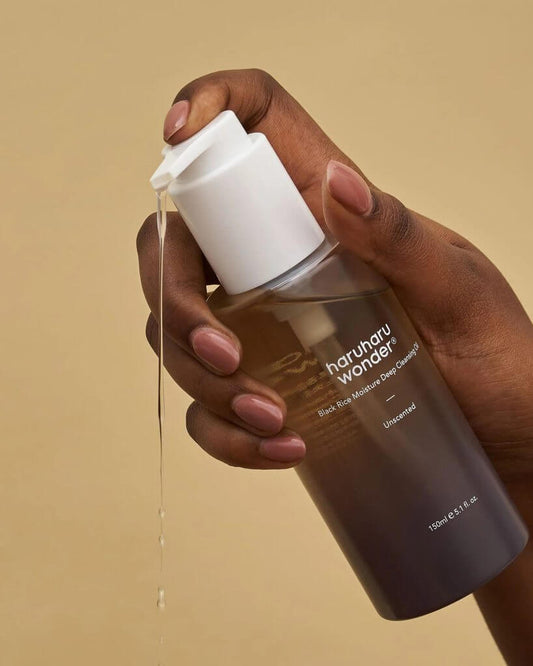 Haruharu Wonder Black Rice Moisture Deep Cleansing Oil in hand, showcasing its natural, gentle formula.