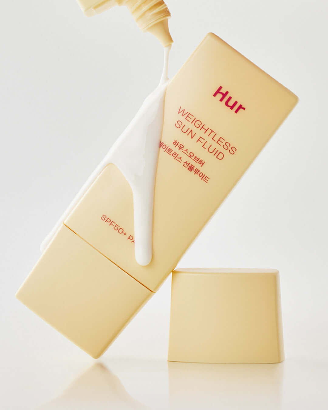 House of Hur Weightless Sun Fluid bottle dispensing sunscreen with a smooth, creamy texture.