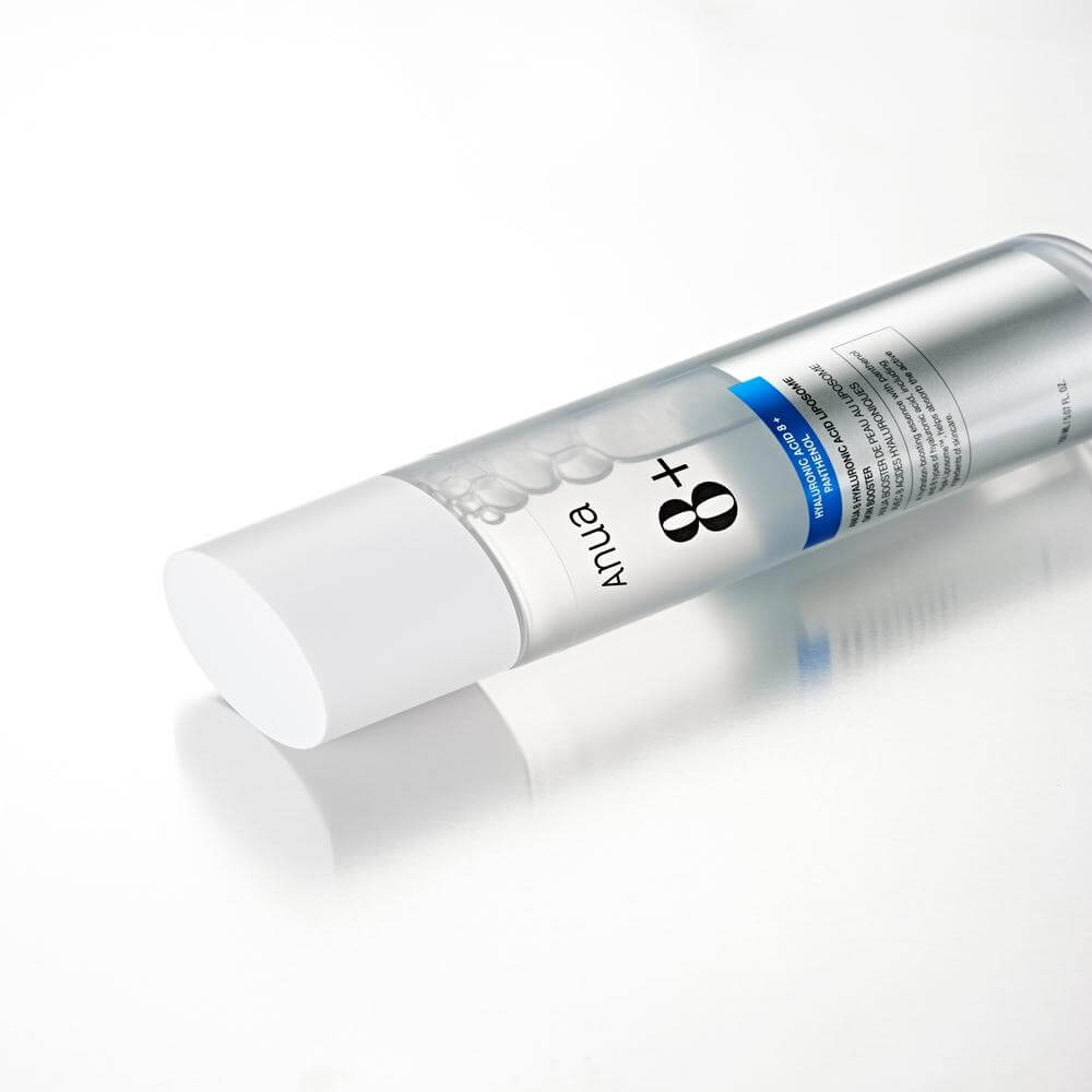 Anua 8 Hyaluronic Acid Liposome Skin Booster bottle on a reflective surface, showcasing its hydrating essence.