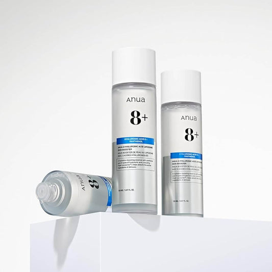 Anua 8 Hyaluronic Acid Liposome Skin Booster bottles on a white surface, showcasing hydrating skincare essence.