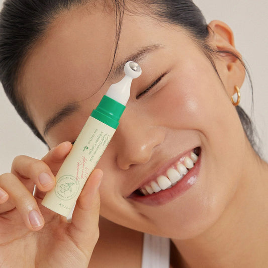 Axis-Y Vegan Collagen Eye Serum being applied by a smiling woman to reduce puffiness and dark circles.