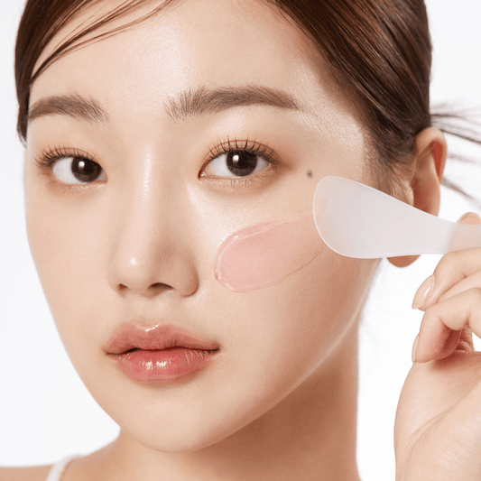 Woman applying Medicube Collagen Jelly Cream on her face with a spatula, showcasing its jelly-like texture.