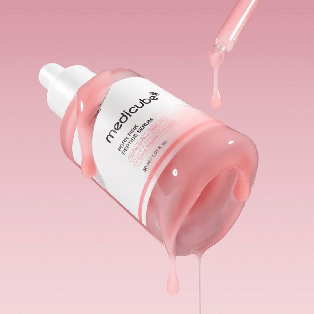 Medicube PDRN Pink Peptide Serum bottle with serum dripping, promoting even skin tone and elasticity.