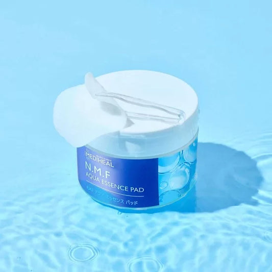 Mediheal N.M.F Aqua Essence Pad jar on a blue background, exfoliating pads for skin care, 50 pieces.