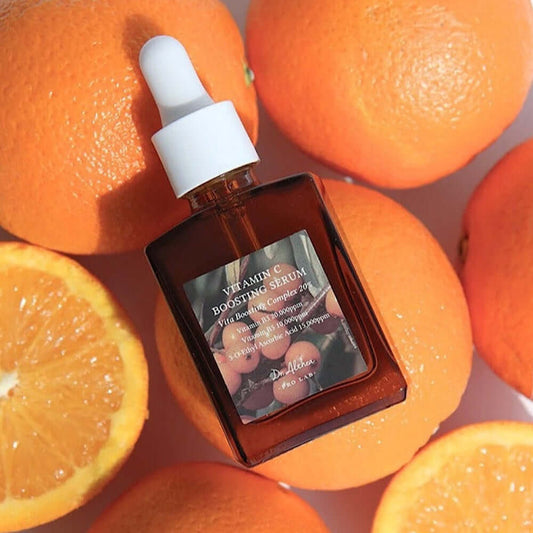 Dr. Althea Vitamin C Boosting Serum bottle surrounded by fresh oranges, designed for brightening skin and reducing blemishes.