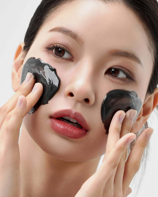 Woman applying House of Hur Midnight Cleansing Balm on her face for makeup removal and skin hydration.