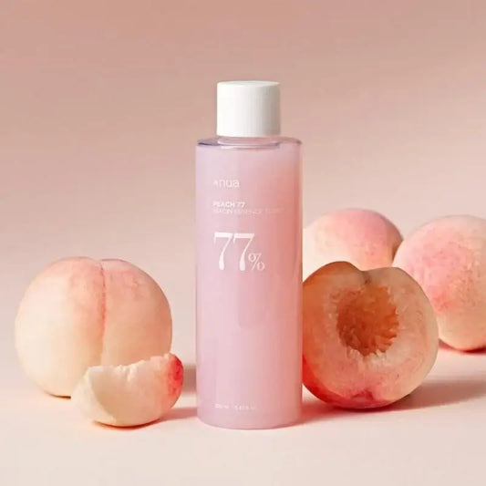 ANUA Peach 77 Niacin Conditioning Milk surrounded by fresh peaches on a pastel background.